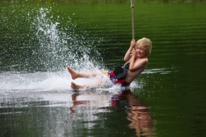 Splash! A young camper enjoys the zip line at Youth Camp, 2013.